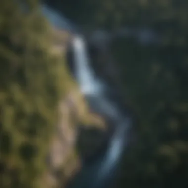 Aerial Perspective of Virginia's Natural Heritage An aerial view capturing the vast expanse of forest surrounding a magnificent waterfall